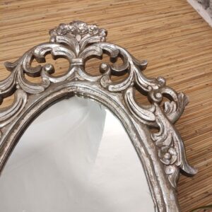 dettaglio della decorazione di specchio ovale argentato in legno