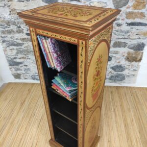 vista laterale di mobiletto indiano a colonna decorato oro e fiori
