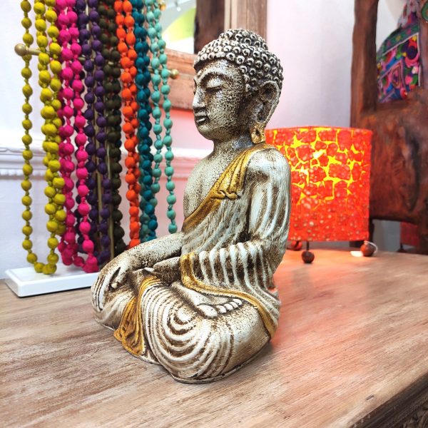 statua buddha thailandia in meditazione bianco oro posizione fiore di loto vista laterale
