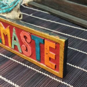 dettaglio della scritta namaste incisa su legno e dipinta
