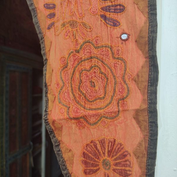 arazzo indiano sopra porta arancione decorazione in stoffa. dettaglio del ricamo con specchietti
