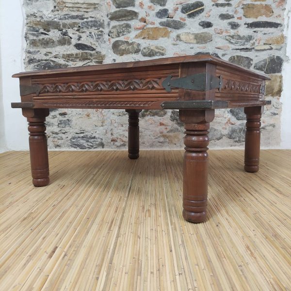 dettaglio delle gambe tornite di tavolino da salotto indiano in legno con rinforzi in metallo