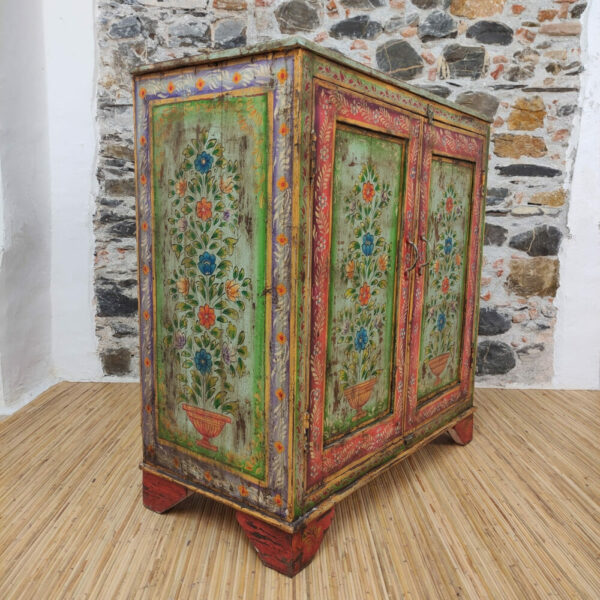 vista laterale di credenza indiana dipinta a fiori verde e rossa