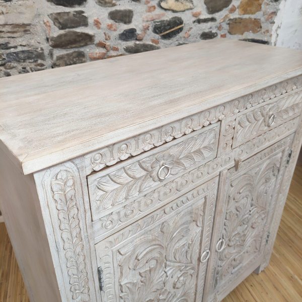 Credenza bianca intagliata con motivi floreali.