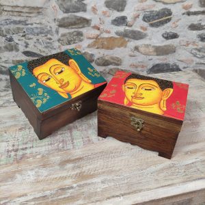 portagioie in legno con volto del Buddha. sfondo rosso o verde
