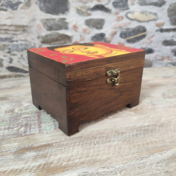 portagioie in legno con volto del Buddha su sfondo colorato rosso