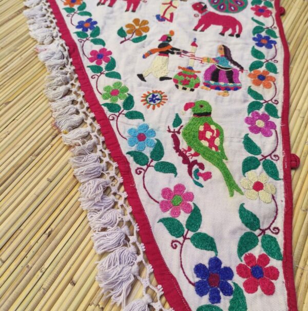 dettaglio di fiori e pappagallo ricamati su sovraporta indiano ad arco