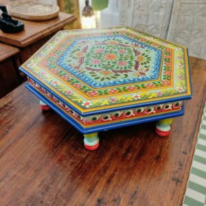 Tavolino basso esagonale in legno dipinto a mano con motivi floreali indiani e piedini sagomati.