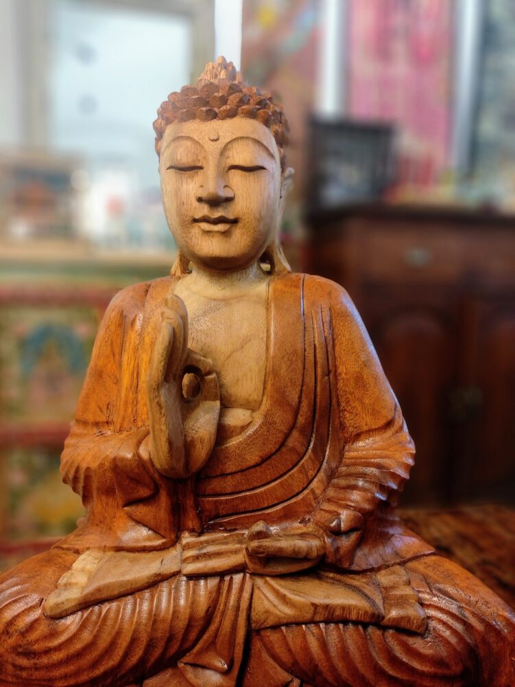 dettaglio di statua del buddha in meditazione in legno