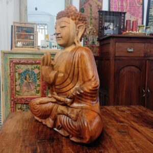 profilo di statua in legno del buddha in meditazione vitarka mudra