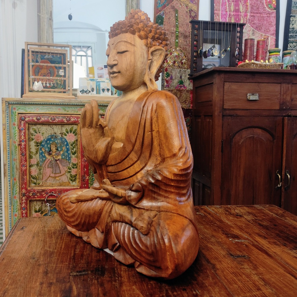 profilo di statua in legno del buddha in meditazione vitarka mudra